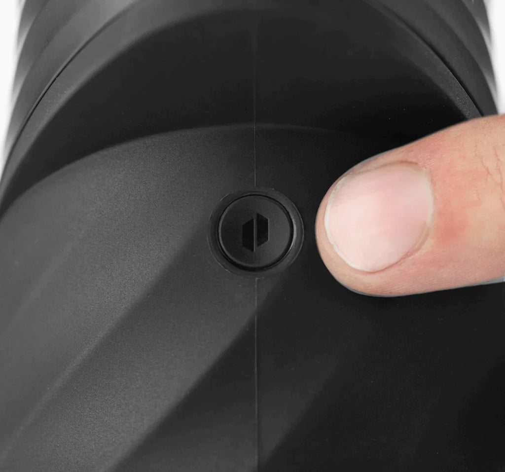 Close up shot of a finger gesturing towards the single-button on a black new peak pro