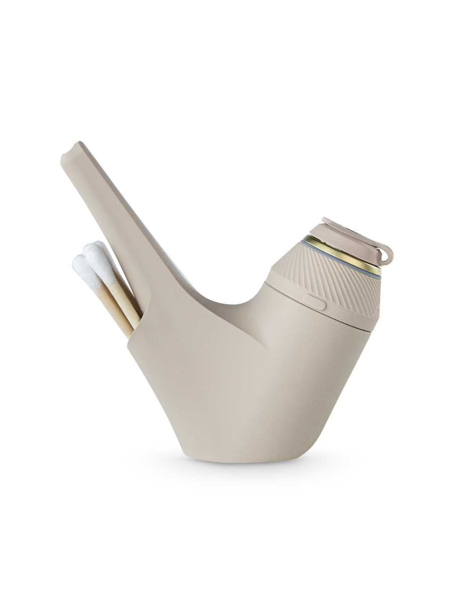 Side shot of beige Puffco Proxy travel pipe with beige base and cotton swabs in back compartment
