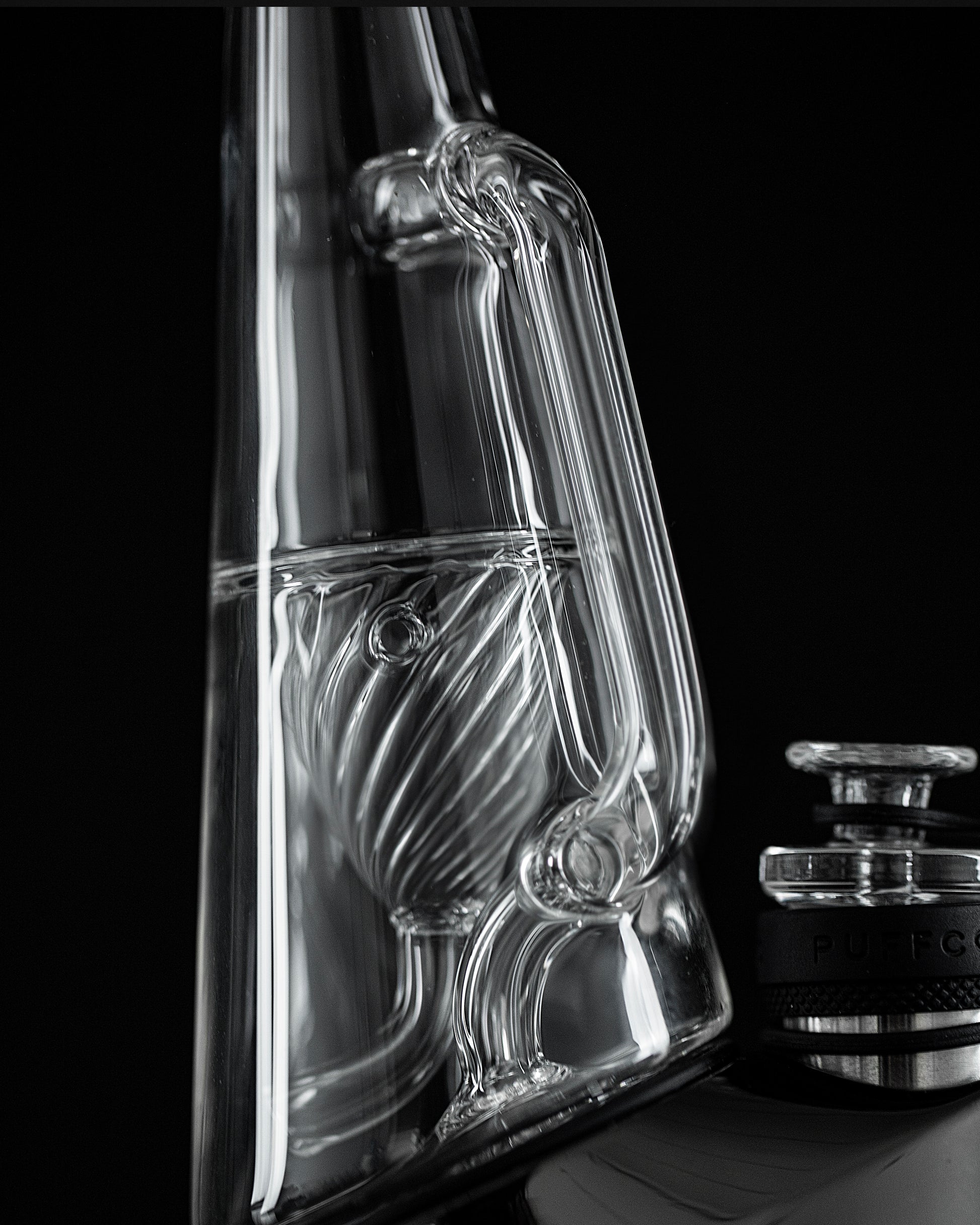 Close up side shot of Ryan Fitt recycler glass peak pro on black dab rig against black backdrop