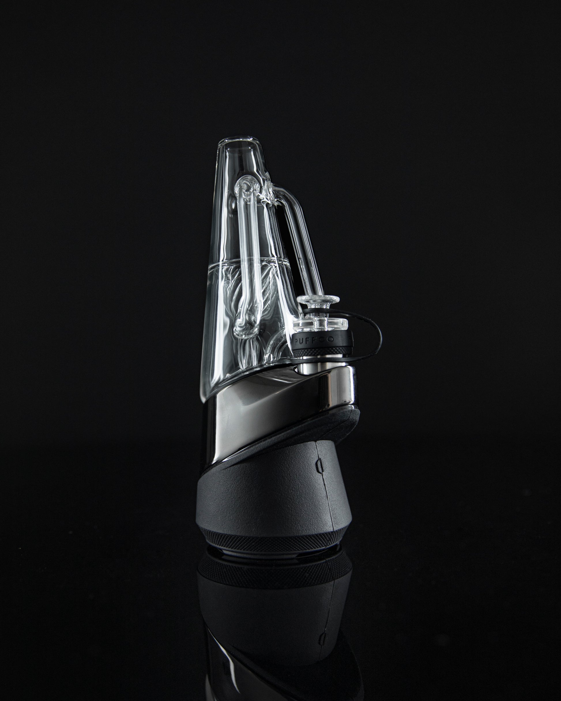 Angled side shot of Ryan Fitt glass on black dab rig against black backdrop