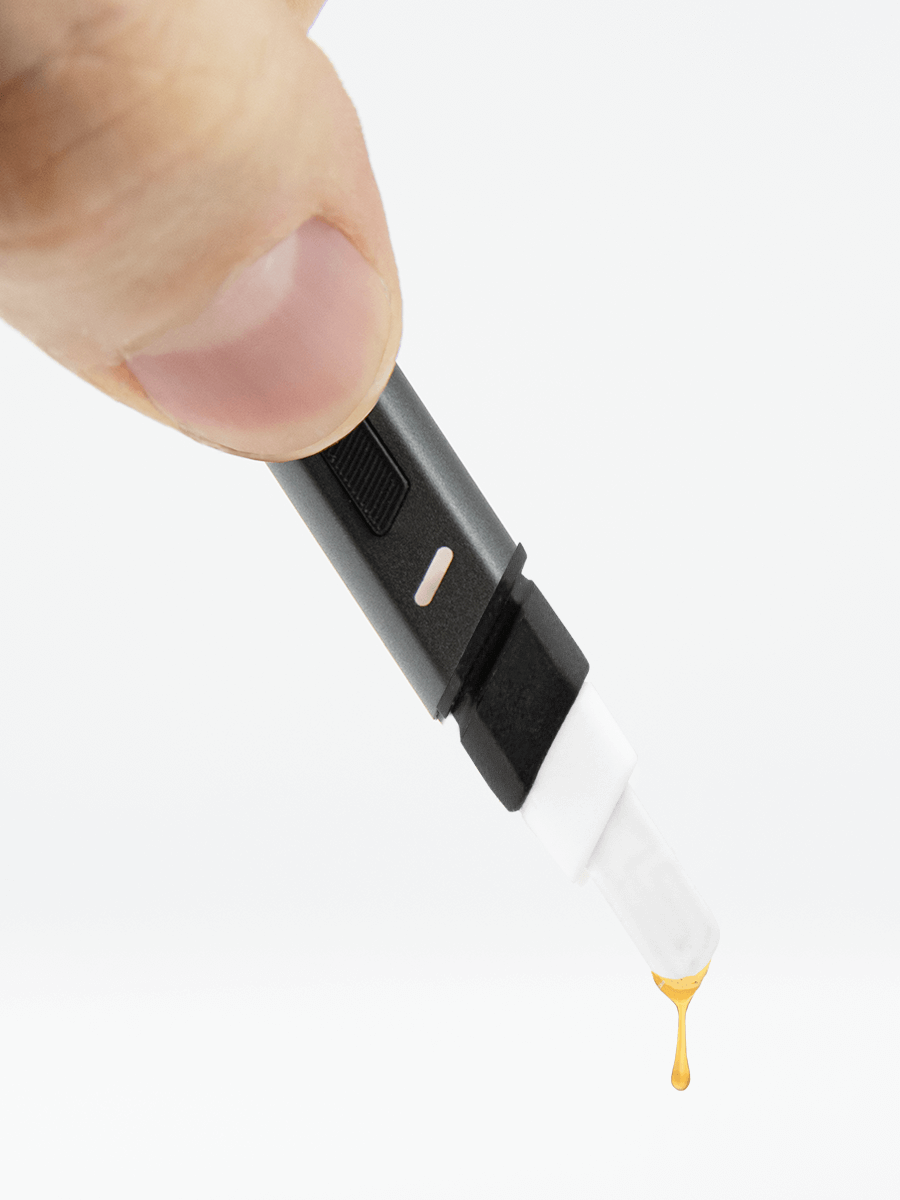 Downwards facing Puffco black dab hot knife with extract dripping off of white tip
