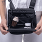 Close up of a person holding open the main compartment with protective padding of black Puffco Proxy bag with pipe and accessories inside